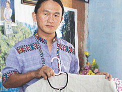 Ko Dee Tan displays hemp clothing made in Kachin State.